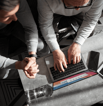 Due persone che guardano il pc e scrivono sul computer